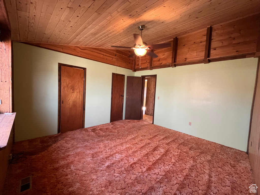 Unfurnished bedroom featuring wood ceiling, ceiling fan, and carpet