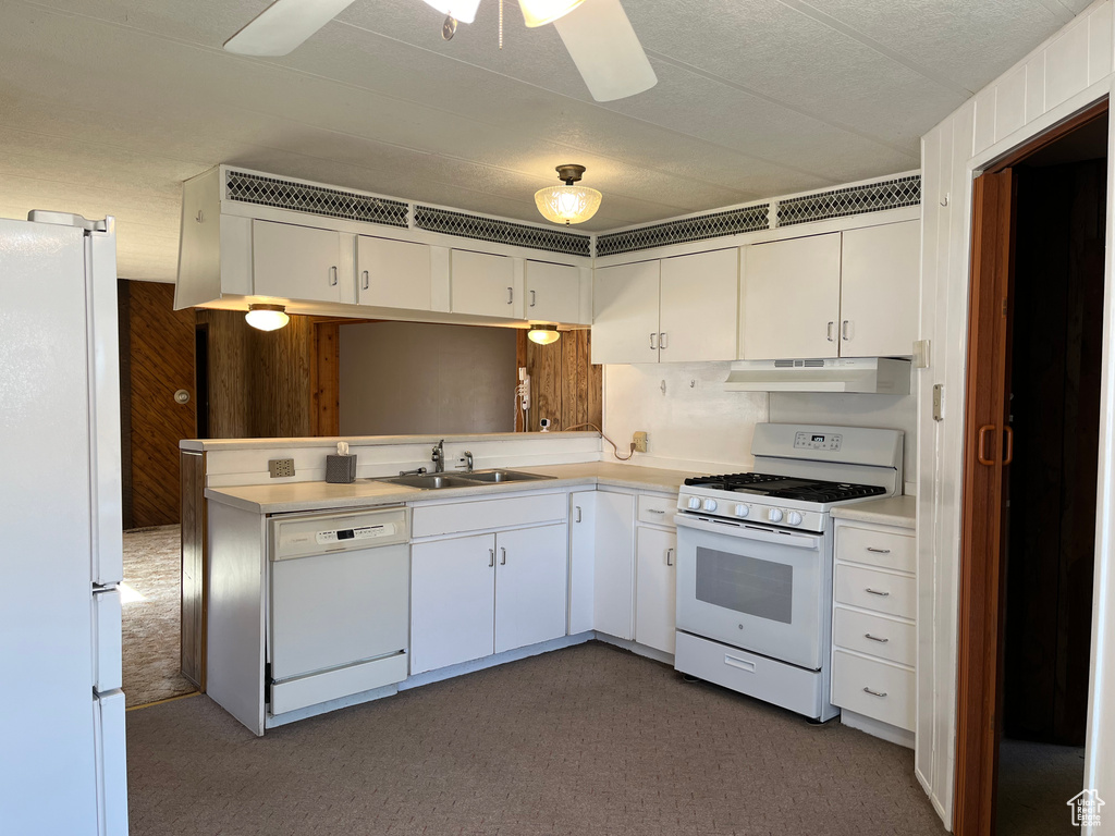 Kitchen featuring white cabinets, ceiling fan, sink, white appliances, and carpet
