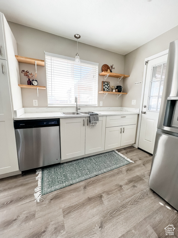Kitchen featuring light hardwood / wood-style floors, plenty of natural light, stainless steel appliances, and sink