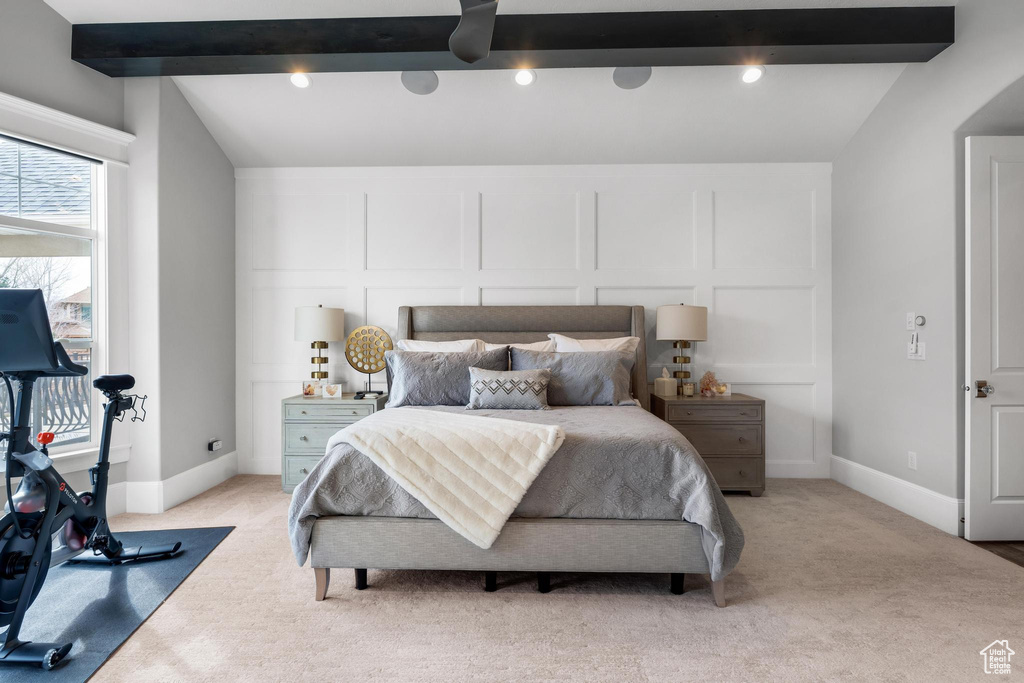Bedroom featuring lofted ceiling with beams and light carpet