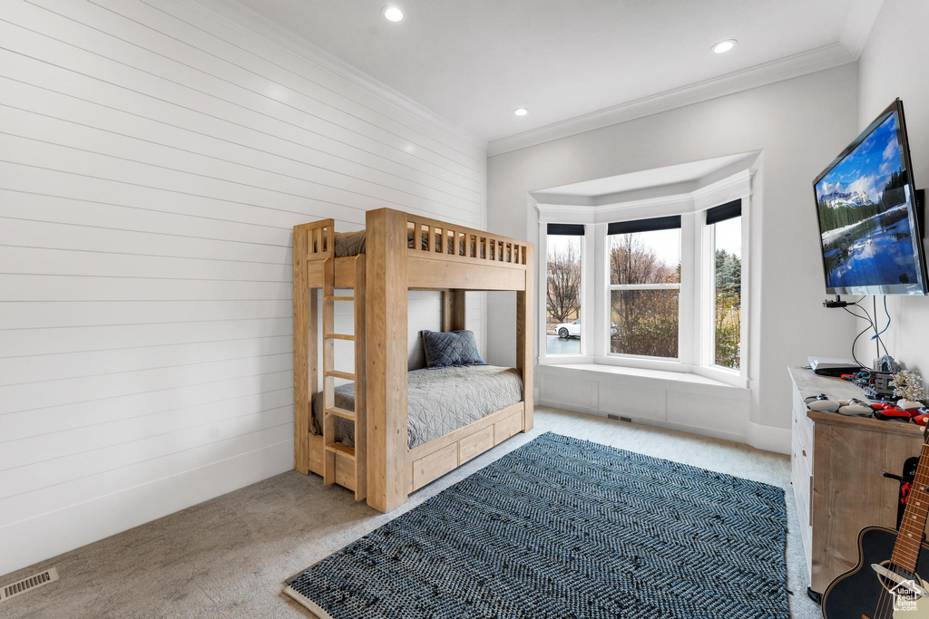 Bedroom with crown molding and light colored carpet