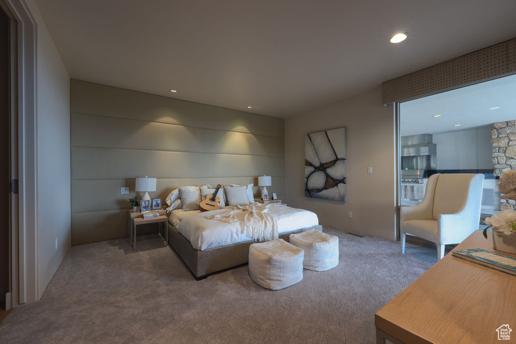 Carpeted bedroom featuring a stone fireplace