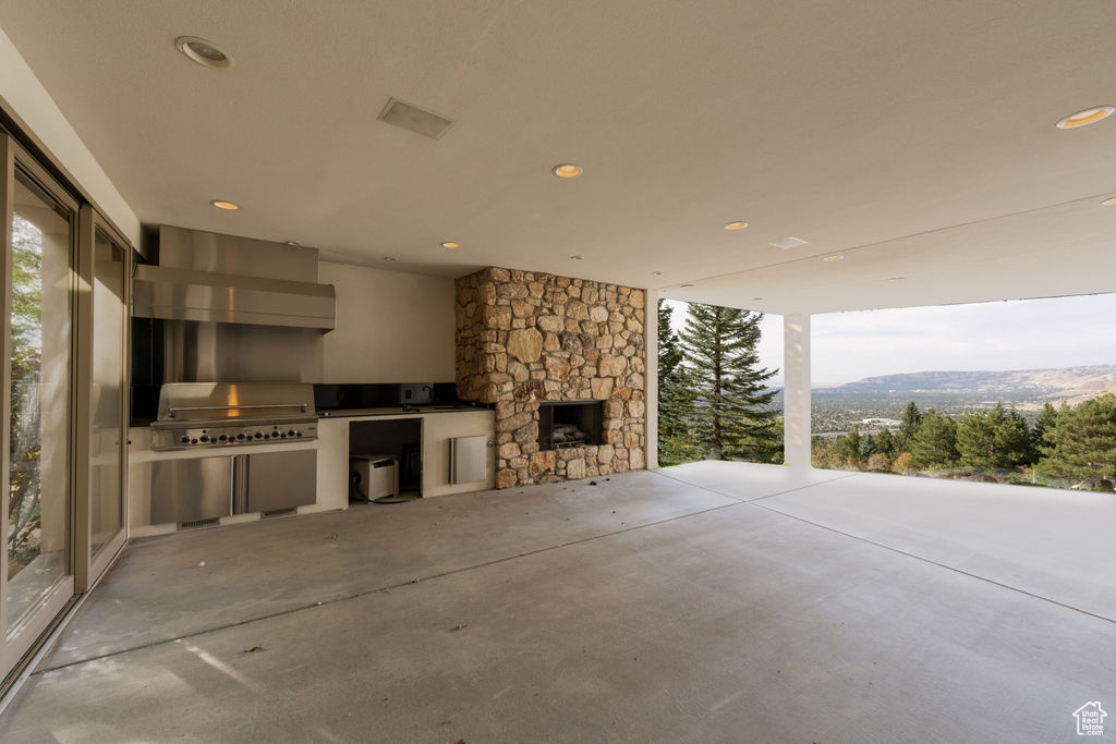 View of patio featuring a mountain view, grilling area, and exterior kitchen