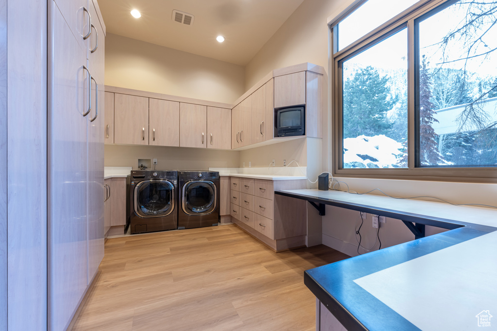 Laundry room with cabinets, light hardwood / wood-style floors, separate washer and dryer, and hookup for a washing machine