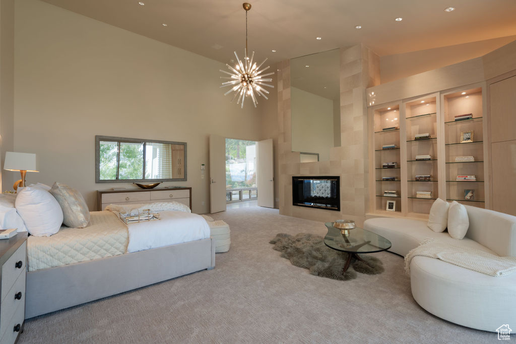 Bedroom with a fireplace, high vaulted ceiling, carpet floors, and an inviting chandelier