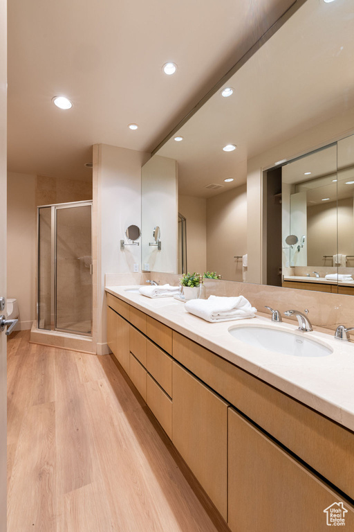 Bathroom featuring walk in shower, hardwood / wood-style floors, and vanity