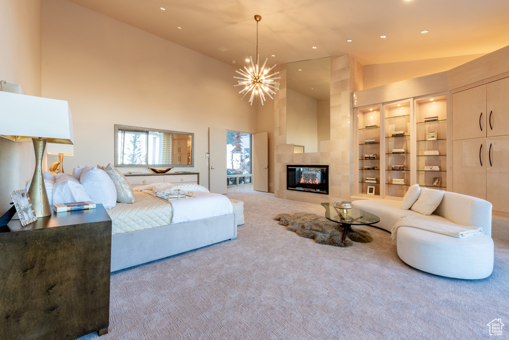 Bedroom with a fireplace, light carpet, high vaulted ceiling, and a notable chandelier
