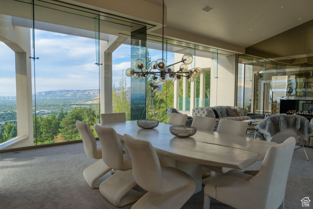 Carpeted dining area featuring a mountain view, plenty of natural light, and an inviting chandelier