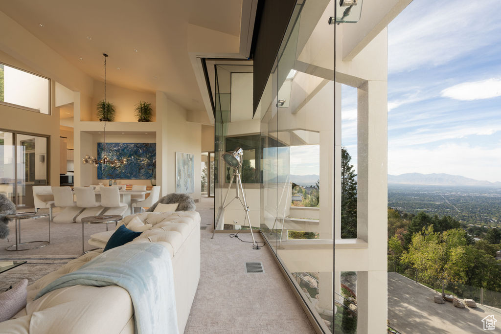 Living room featuring a high ceiling, a mountain view, and carpet flooring