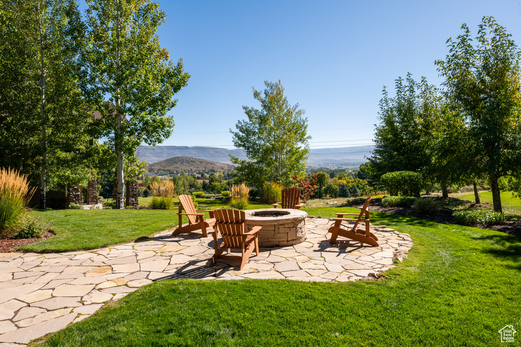 View of yard featuring a patio area, an outdoor fire pit, and a mountain view