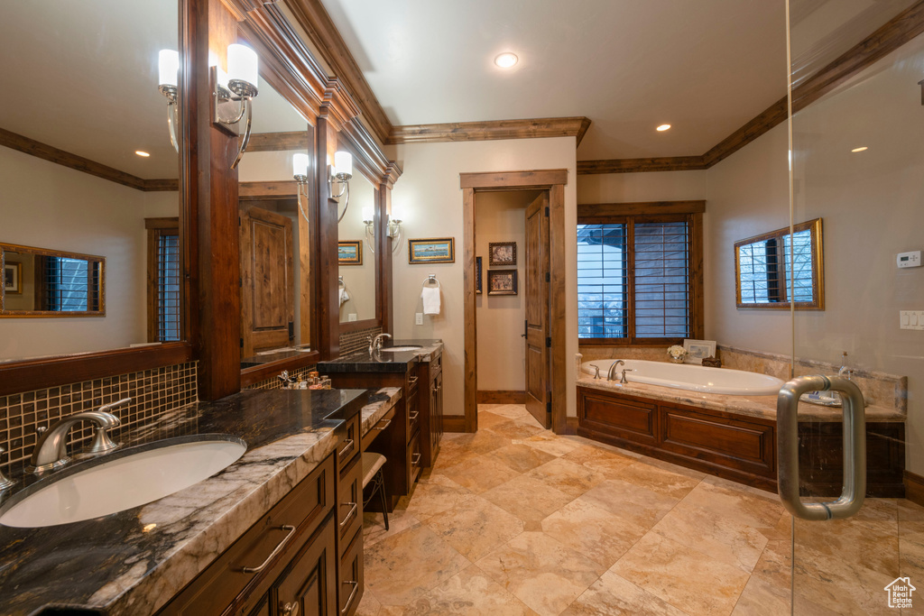 Bathroom featuring a bathtub, dual bowl vanity, crown molding, and tile flooring