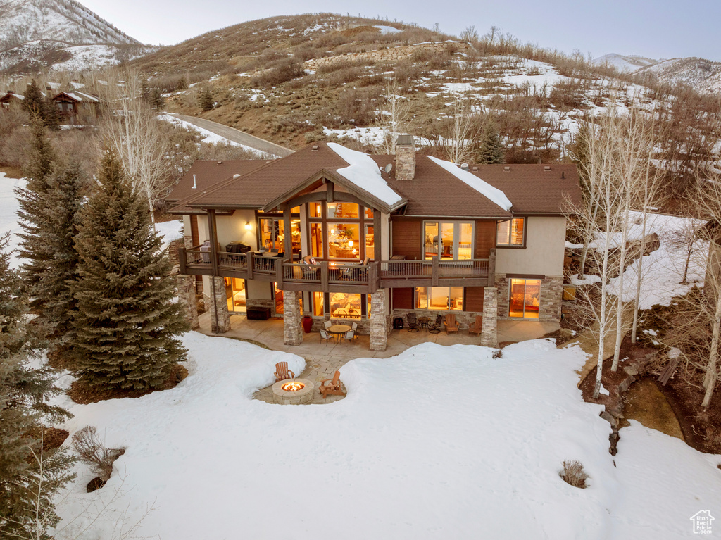Snow covered property featuring a mountain view and a balcony