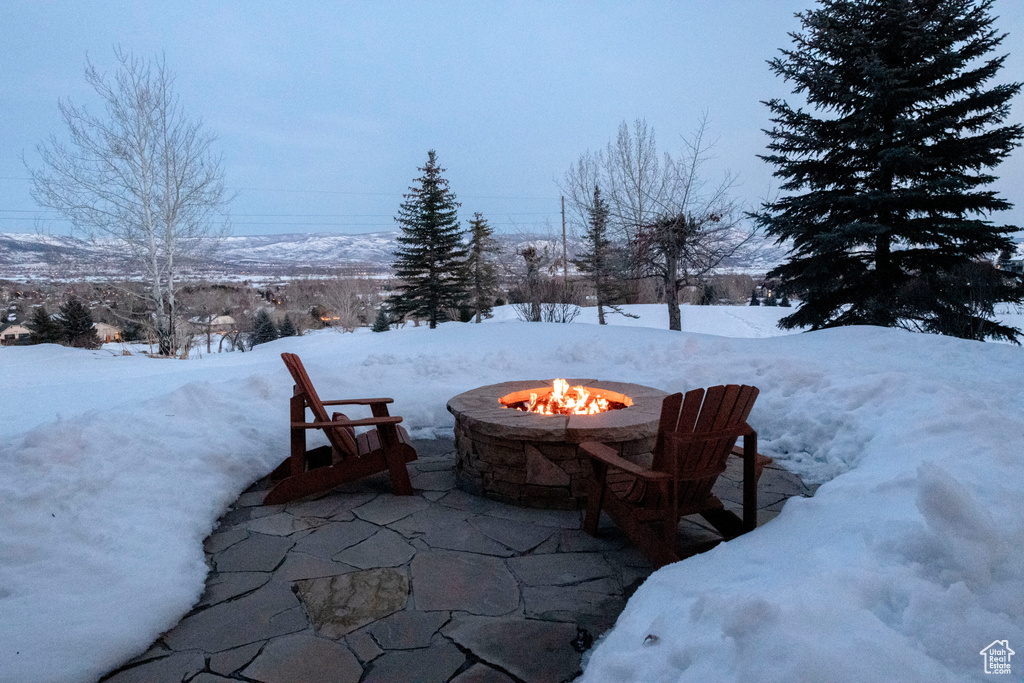 Snow covered patio featuring a fire pit