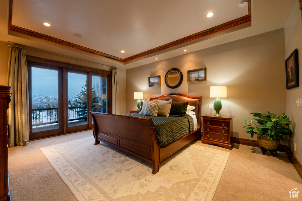 Bedroom with light carpet, a raised ceiling, ornamental molding, and access to exterior
