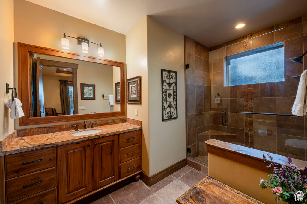 Bathroom with vanity, tile floors, and an enclosed shower