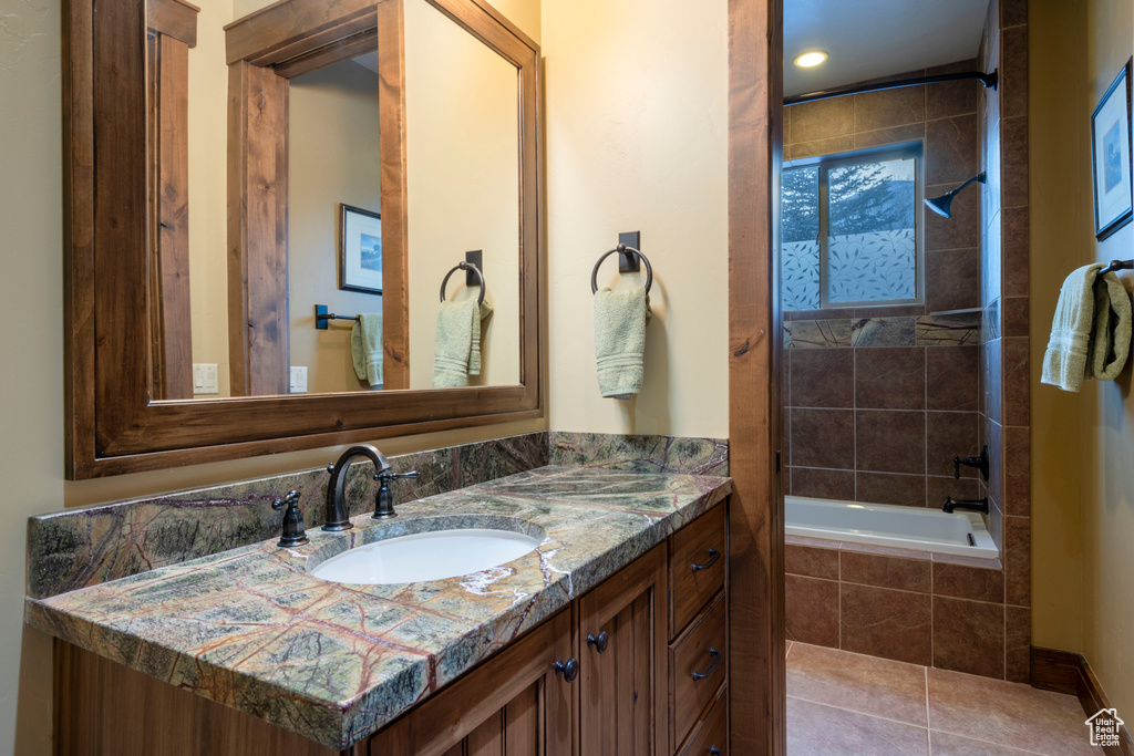 Bathroom featuring tile floors, tiled shower / bath, and vanity