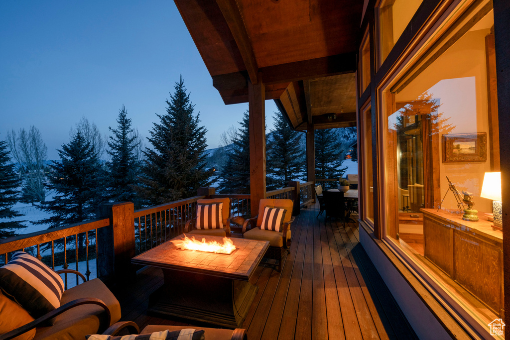 Deck at dusk featuring a fire pit