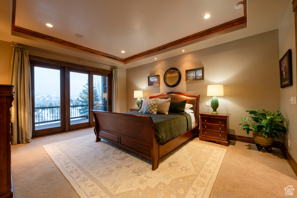 Bedroom featuring light carpet, crown molding, a raised ceiling, and access to exterior