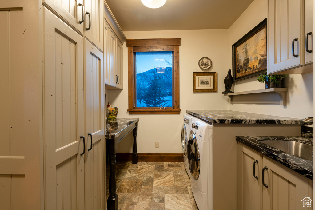 Laundry room featuring cabinets, sink, washing machine and dryer, and tile flooring