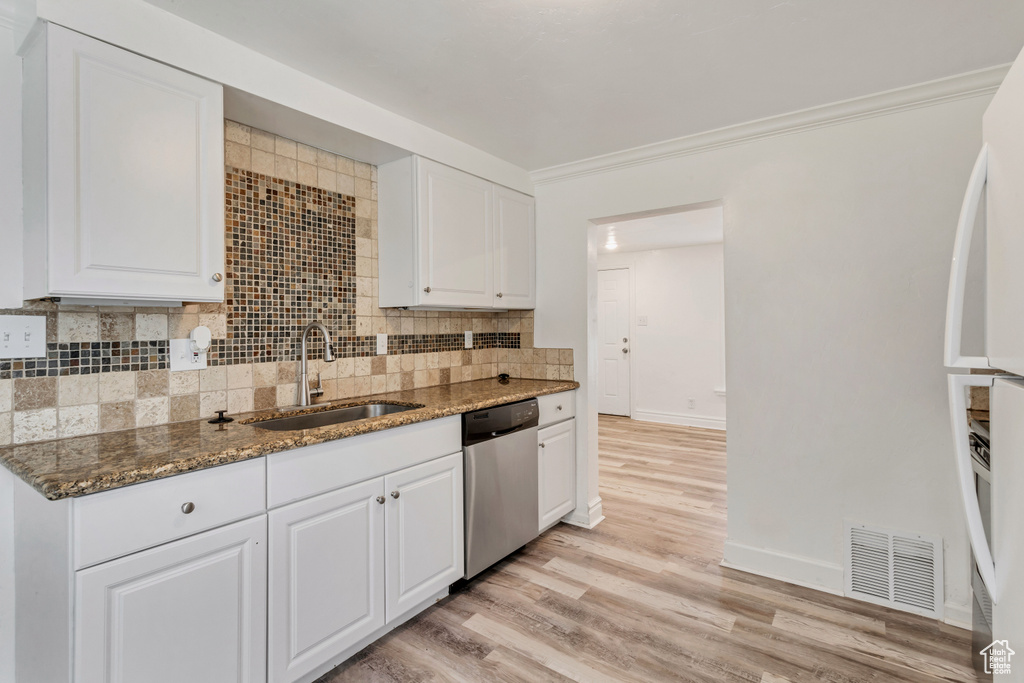 Kitchen with light hardwood / wood-style flooring, dishwasher, and white cabinets