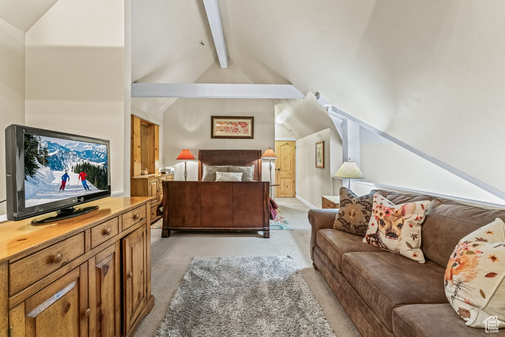 Carpeted living room with vaulted ceiling with beams