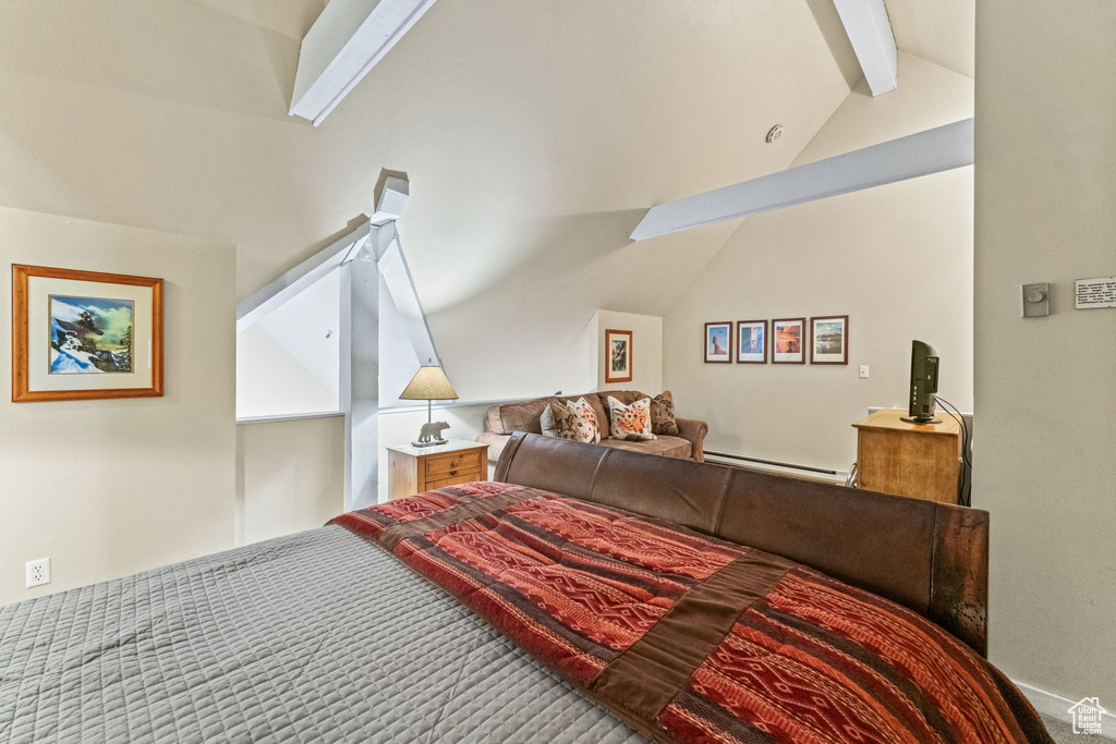 Bedroom with a baseboard heating unit and lofted ceiling with beams