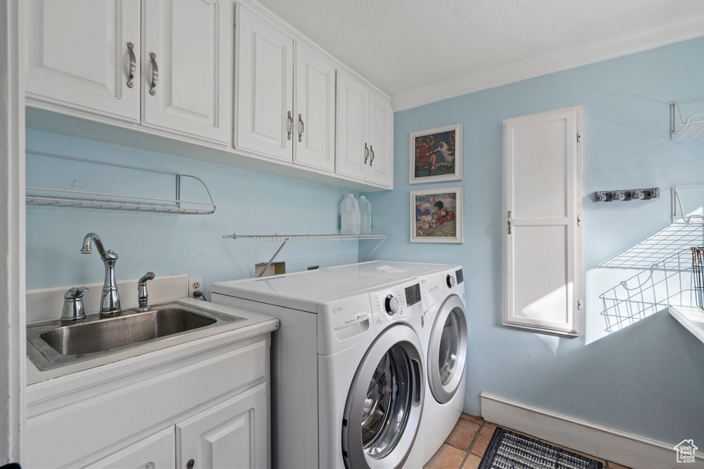 Laundry room with washer and clothes dryer, cabinets, crown molding, sink, and light tile floors