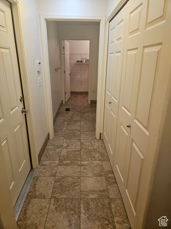 Corridor featuring dark tile floors