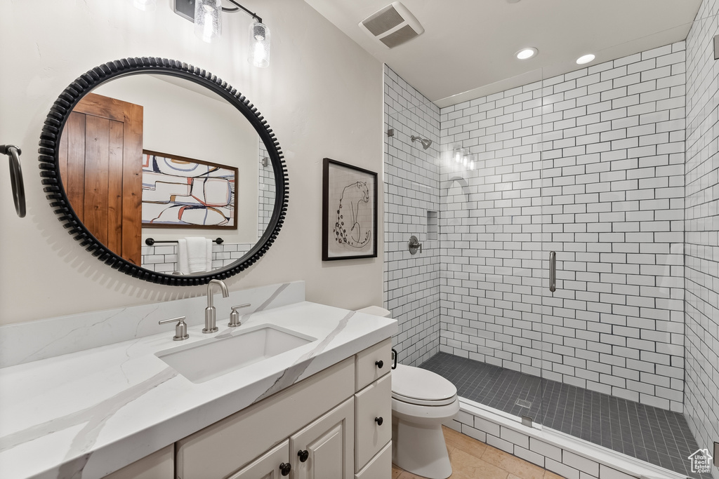 Bathroom featuring vanity, an enclosed shower, tile flooring, and toilet