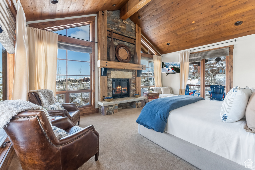 Bedroom featuring a stone fireplace, beam ceiling, access to exterior, light colored carpet, and high vaulted ceiling