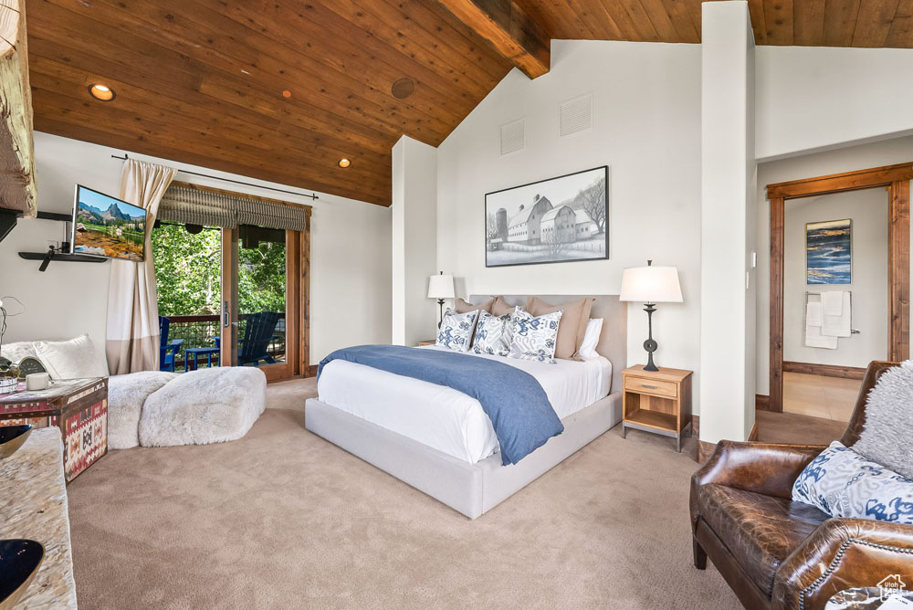 Carpeted bedroom with high vaulted ceiling, wooden ceiling, beam ceiling, and access to exterior