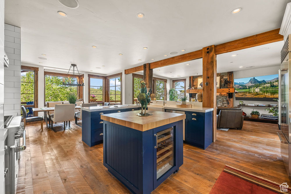 Kitchen featuring blue cabinetry, wine cooler, light hardwood / wood-style floors, and a kitchen island