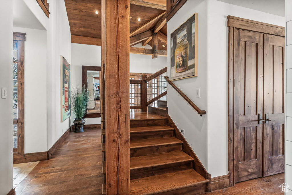 Stairway featuring wood ceiling, dark hardwood / wood-style flooring, and beamed ceiling