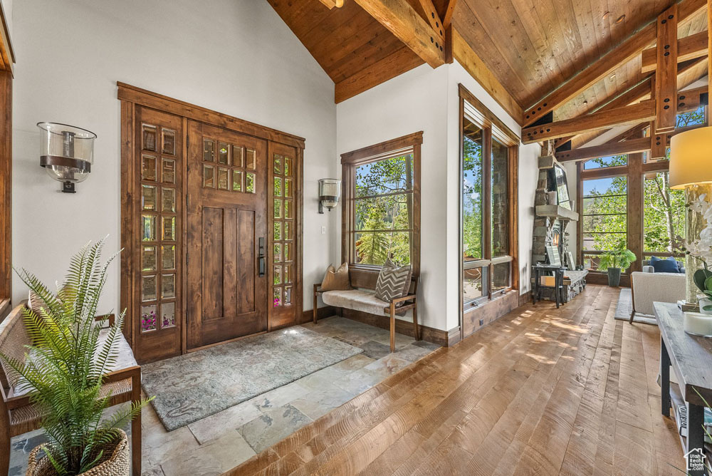 Foyer entrance featuring beam ceiling, a wealth of natural light, wood ceiling, and wood-type flooring