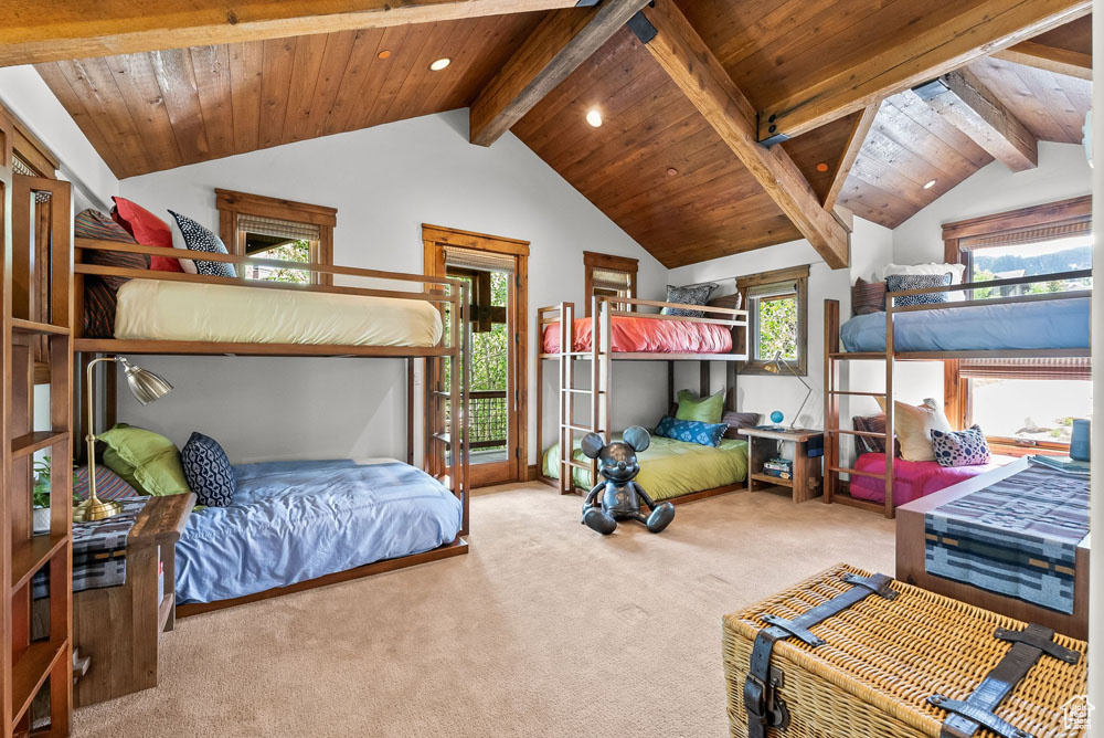 Bedroom with carpet, lofted ceiling with beams, and wooden ceiling