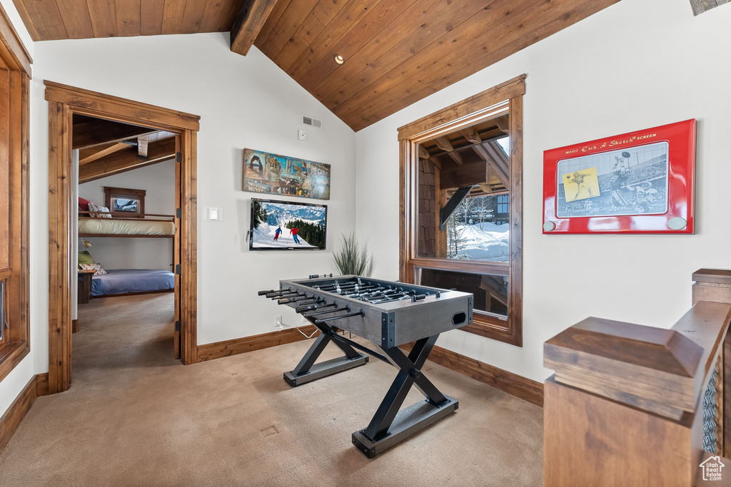 Game room featuring dark colored carpet and lofted ceiling with beams