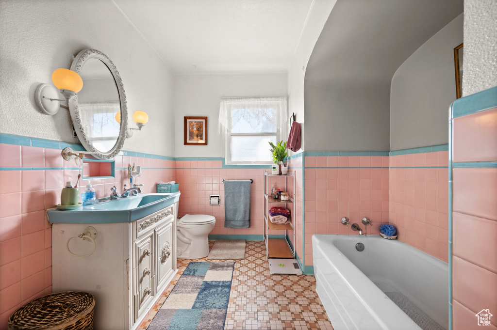 Bathroom with a bathing tub, oversized vanity, tile walls, toilet, and tile floors