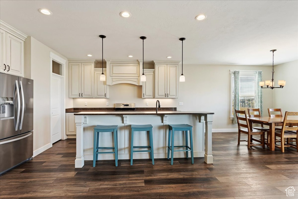Kitchen featuring custom exhaust hood, dark wood-type flooring, an inviting chandelier, decorative light fixtures, and stainless steel refrigerator with ice dispenser
