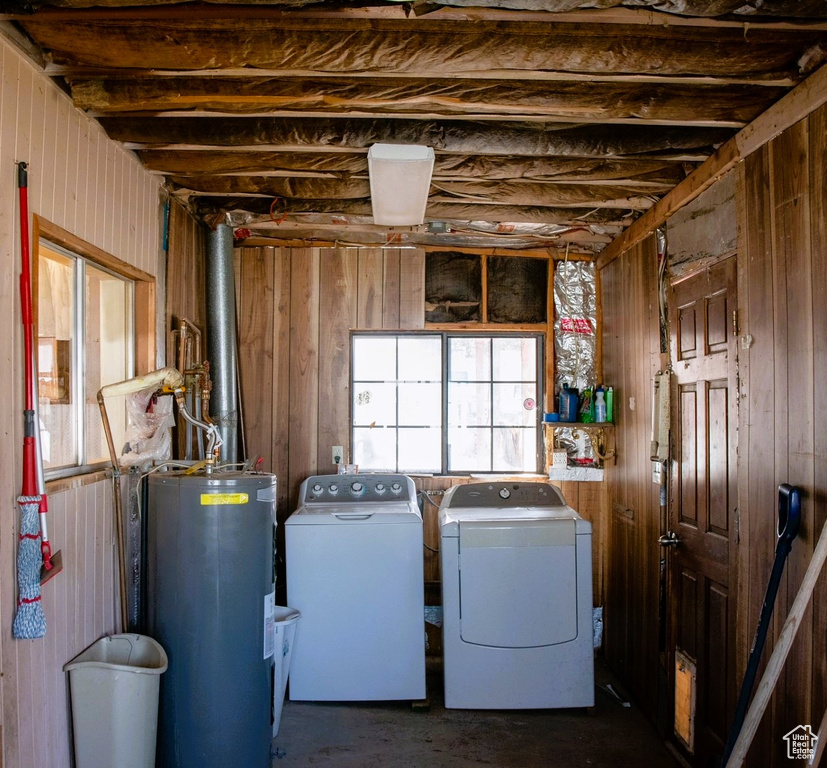 Clothes washing area featuring electric water heater and independent washer and dryer