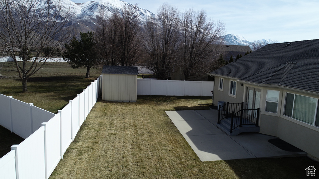 View of yard featuring a patio area, a storage unit, and a mountain view