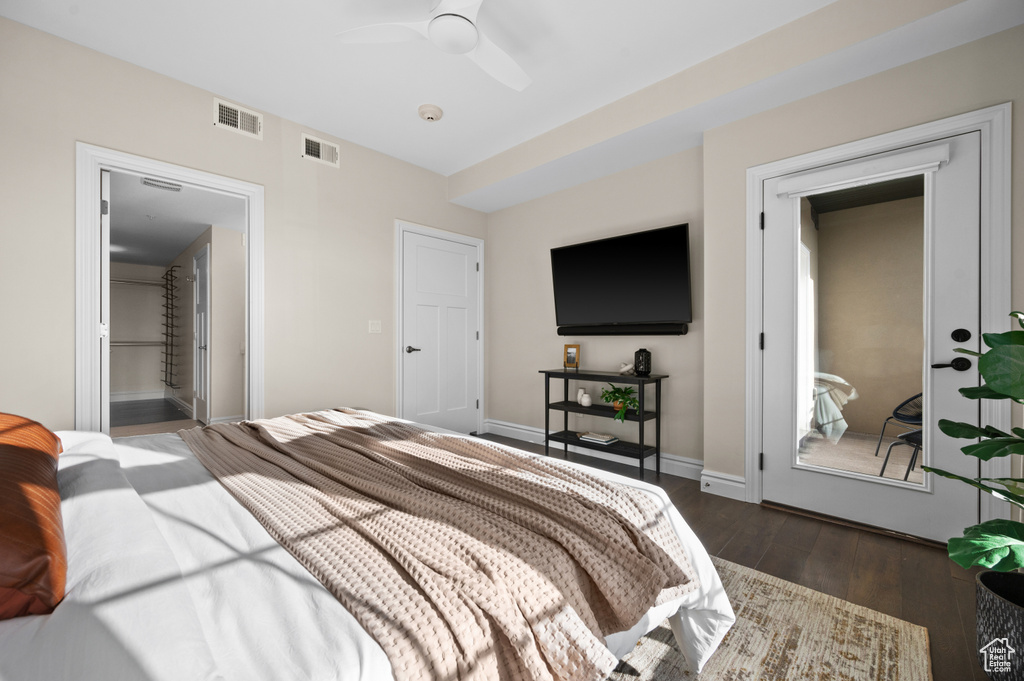 Bedroom with ceiling fan, dark hardwood / wood-style floors, and ensuite bath