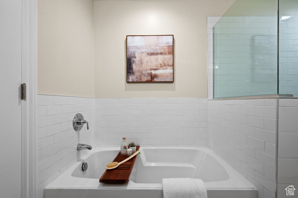 Bathroom featuring a bath and tile walls