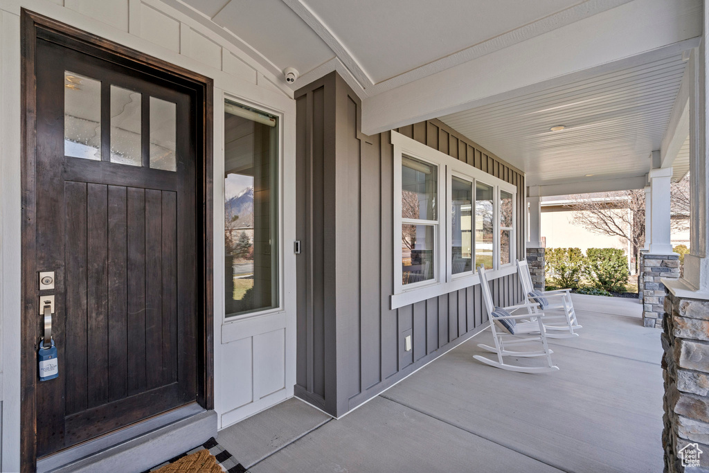 Doorway to property featuring covered porch