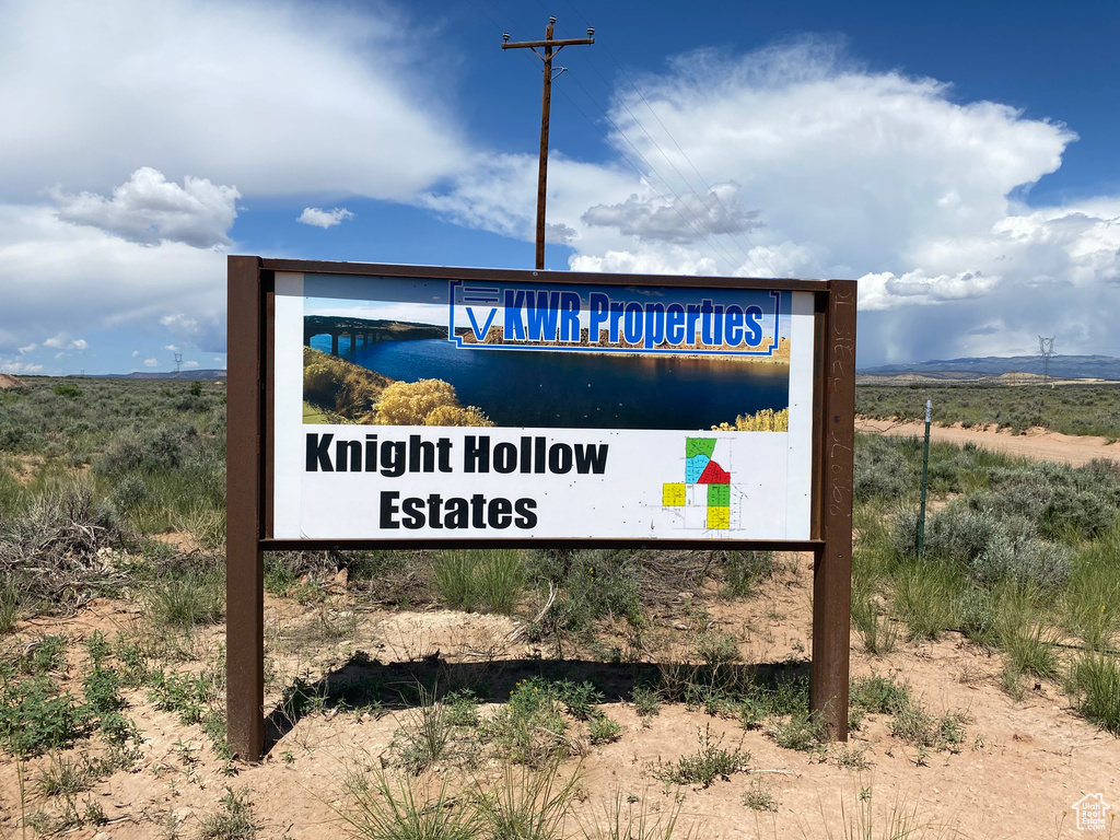 Community / neighborhood sign featuring a rural view