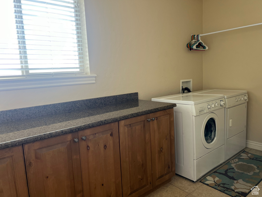 Washroom featuring washer hookup, light tile floors, washer and dryer, and cabinets