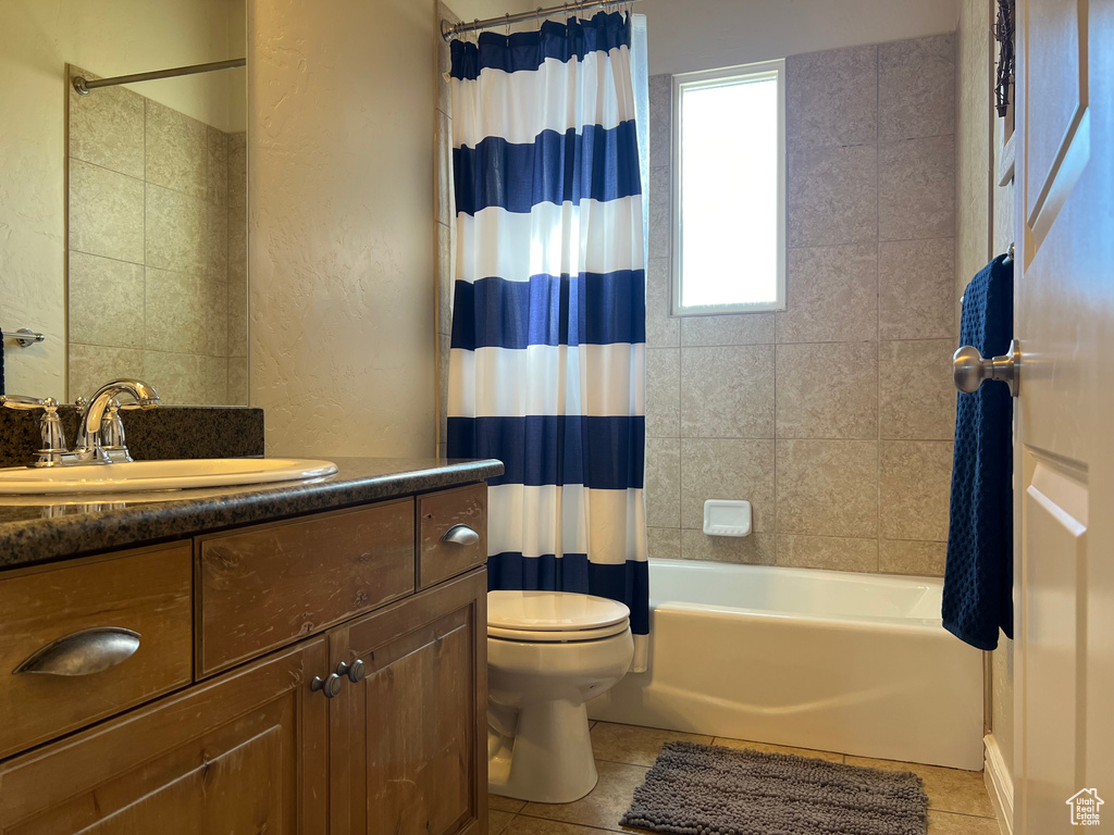 Full bathroom with vanity, toilet, tile flooring, and shower / bath combo with shower curtain