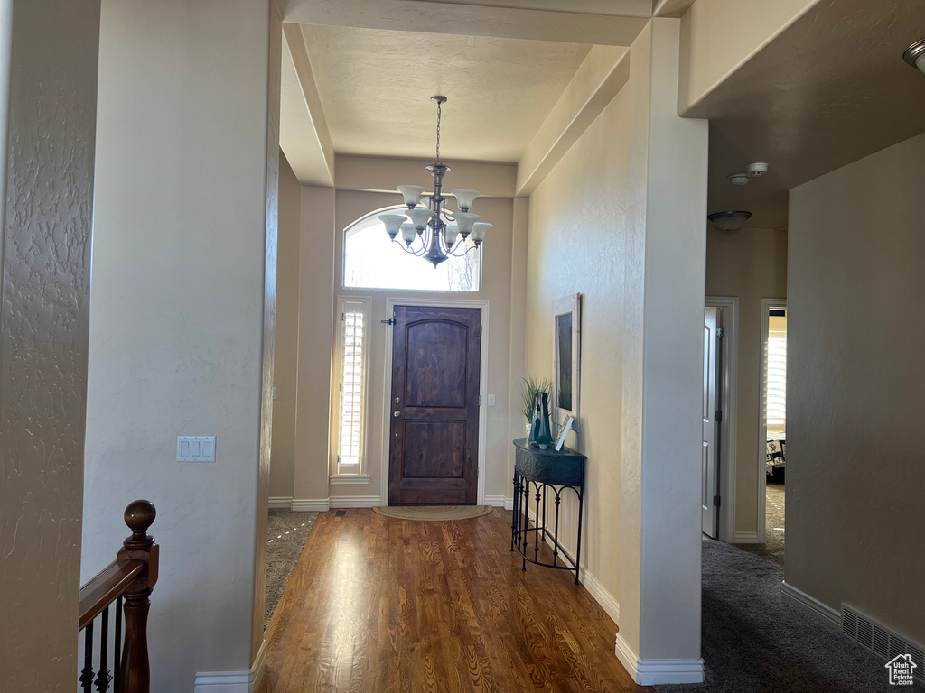 Entryway with a notable chandelier, dark hardwood / wood-style floors, and a healthy amount of sunlight