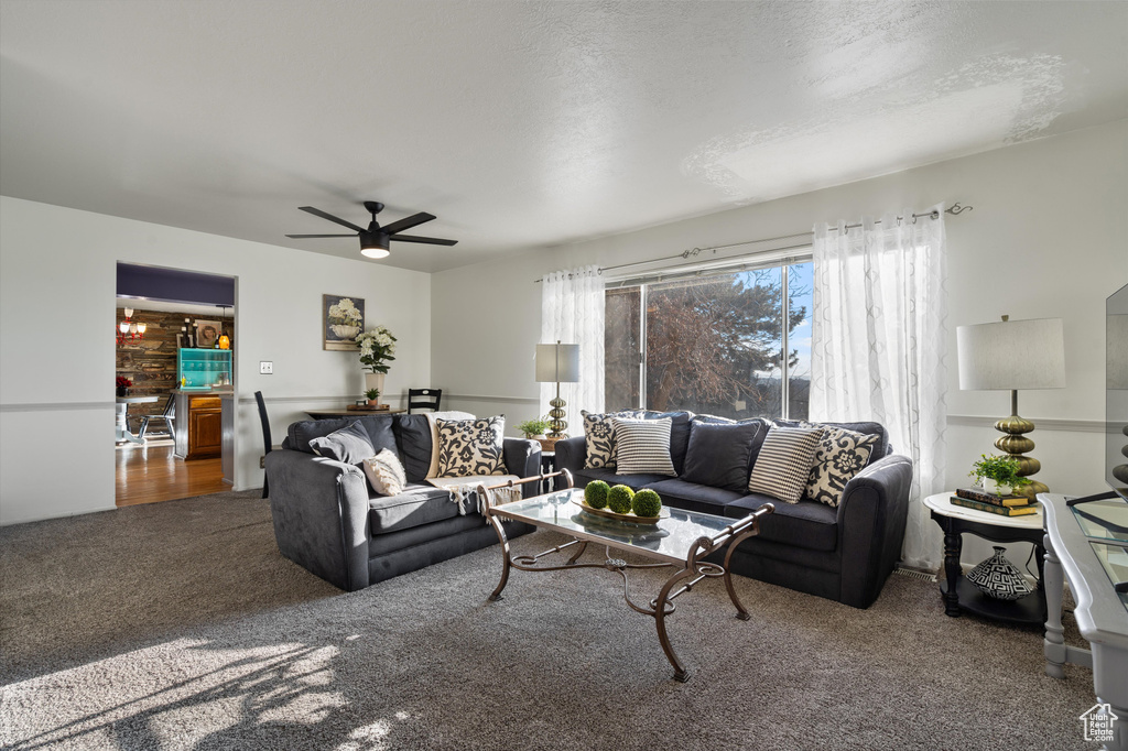 Living room with dark colored carpet and ceiling fan