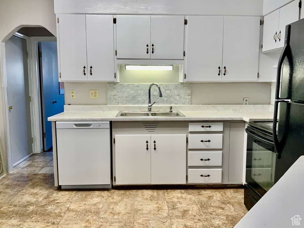 Kitchen featuring black appliances, white cabinetry, tasteful backsplash, sink, and light tile floors