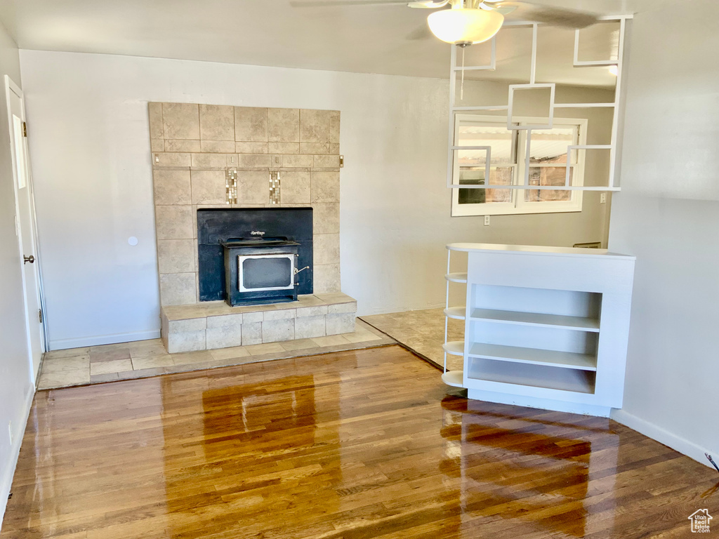 Unfurnished living room with a fireplace, light hardwood / wood-style floors, ceiling fan, and built in features